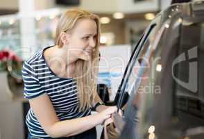 Woman admiring a car at an auto show