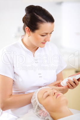 Cosmetician with cosmetic before procedure