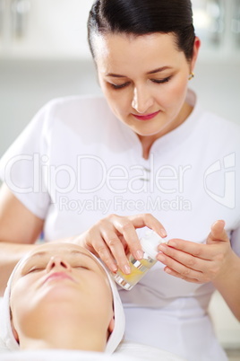 Cosmetician is going to apply facial cosmetic