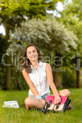 Happy student girl sitting grass open schoolbag
