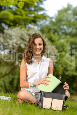 Teenage student woman sitting grass with books