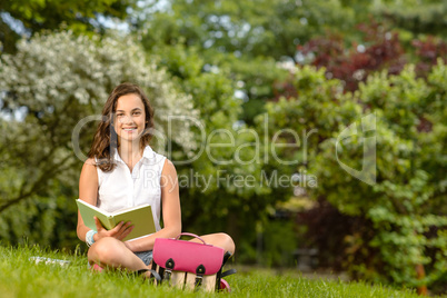 Student girl sitting grass with open book