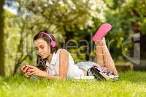 Summer girl lying grass listen music headphones