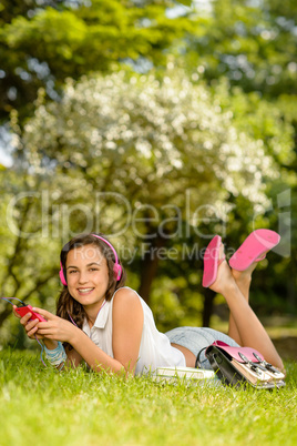 Smiling student girl lying in summer park