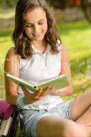 Student girl reading book in park summer