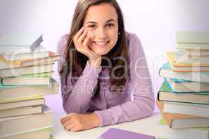 Smiling student girl between stacks of books