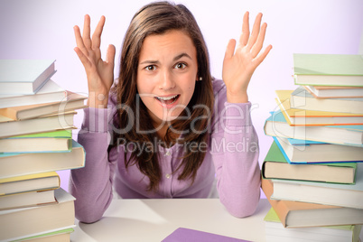 Desperate student girl between stacks of books