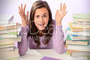 Desperate student girl between stacks of books