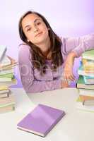 Confident student girl between stacks of books