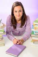 Beautiful student girl sitting between stacks books