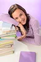 Smiling student girl resting head on books