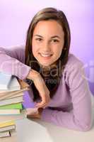 Smiling student girl with pile of books