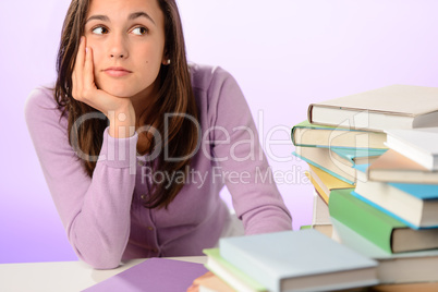 Student girl looking aside stack of books