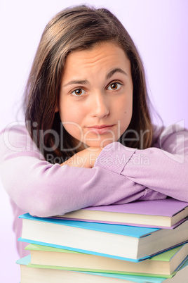 Desperate student girl leaning on stack books