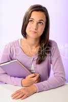 Thinking student girl sitting behind desk purple