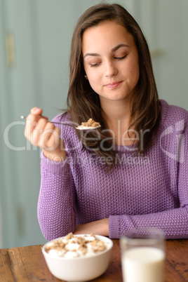 Young woman eating healthy cereal breakfast