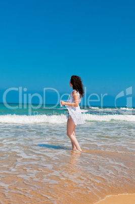 Girl in white cloak  looking at sea