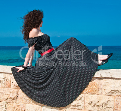 Girl in a beautiful long dress against the sea