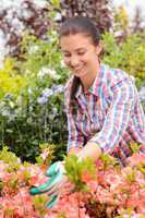 Garden center woman stands in flowerbed smiling