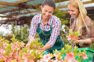 Garden center woman show flowers to customer