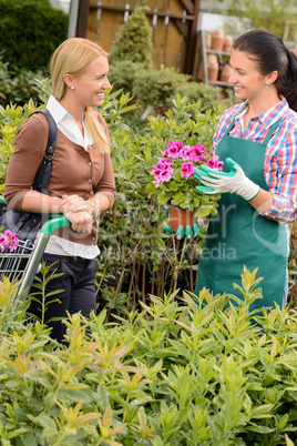 Garden center worker selling potted flower customer