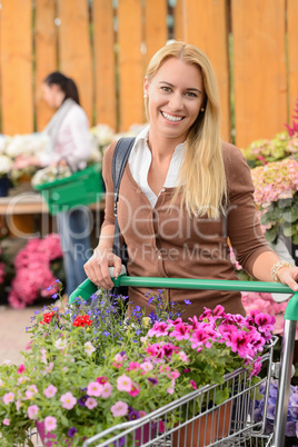 Woman buying flowers shopping cart garden center