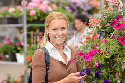 Smiling customer with colorful flowers garden center