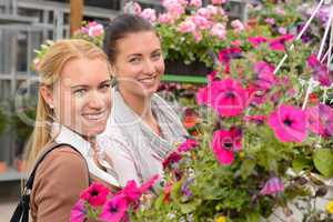 Two woman in garden center colorful flowers