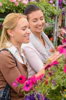 Two women choosing flowers in garden center