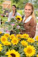 Smiling customer woman shopping for potted sunflower