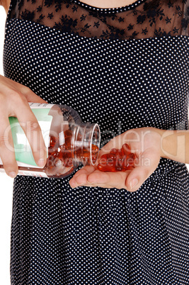 Woman pouring vitamin pills.