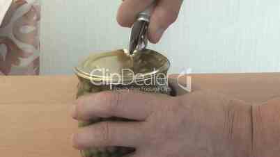 people can opener opens the jar of peas