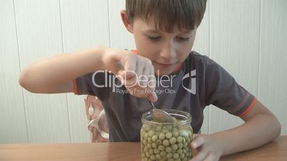 child eats green peas