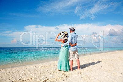 Vacation Couple walking on tropical beach Maldives.
