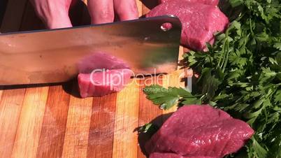 chopping meat with a meat cleaver