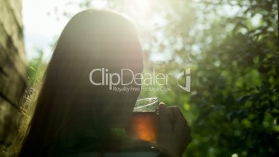 Girl drinking hot tea outdoor at sunset
