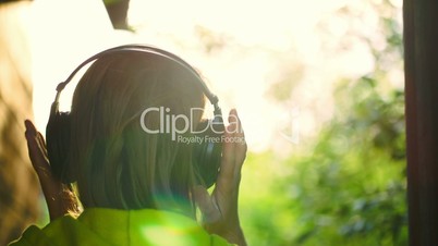 Girl listening to music in headphones outdoor