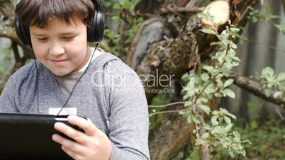 Boy in headphones with touchpad outdoor