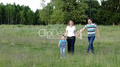 Mother, father and son walking on the meadow