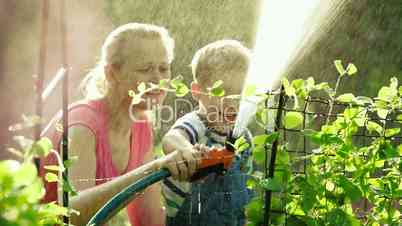 Mom and son watering the garden together