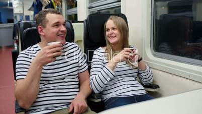 Man and woman drinking tea in train