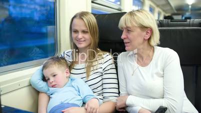 Mother, son and grandmother traveling by train