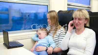 Passengers in the train watching video on laptop and talking phone