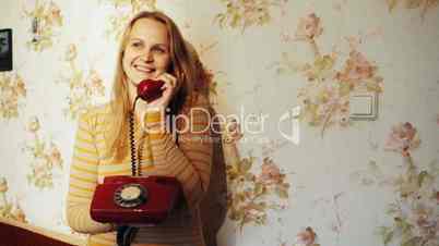 Happy young woman receving a call at home