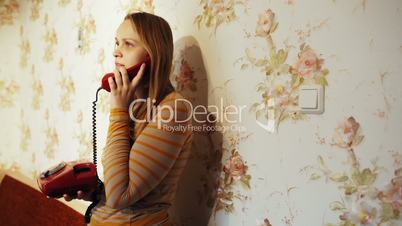 Young woman talking on the phone at home