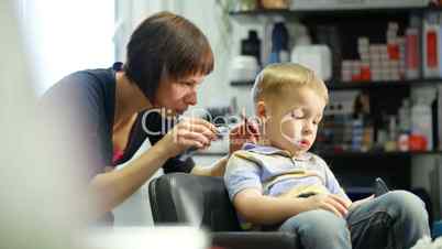 Little boy during haircut at the hairdressing saloon