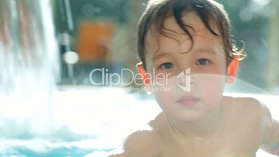 Boy in the swimming pool splashing water