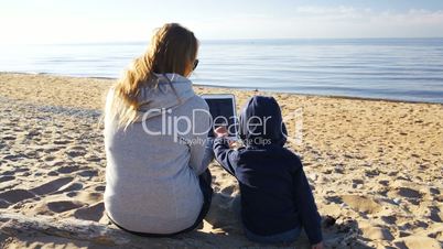 Mother and son on the beach with tablet PC