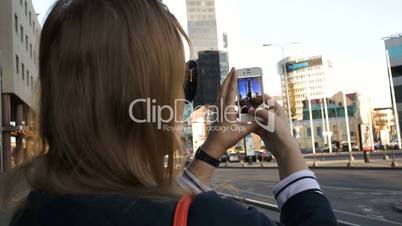 Woman in the city taking pictures with her smartphone