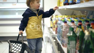 Little boy putting mineral water into the basket